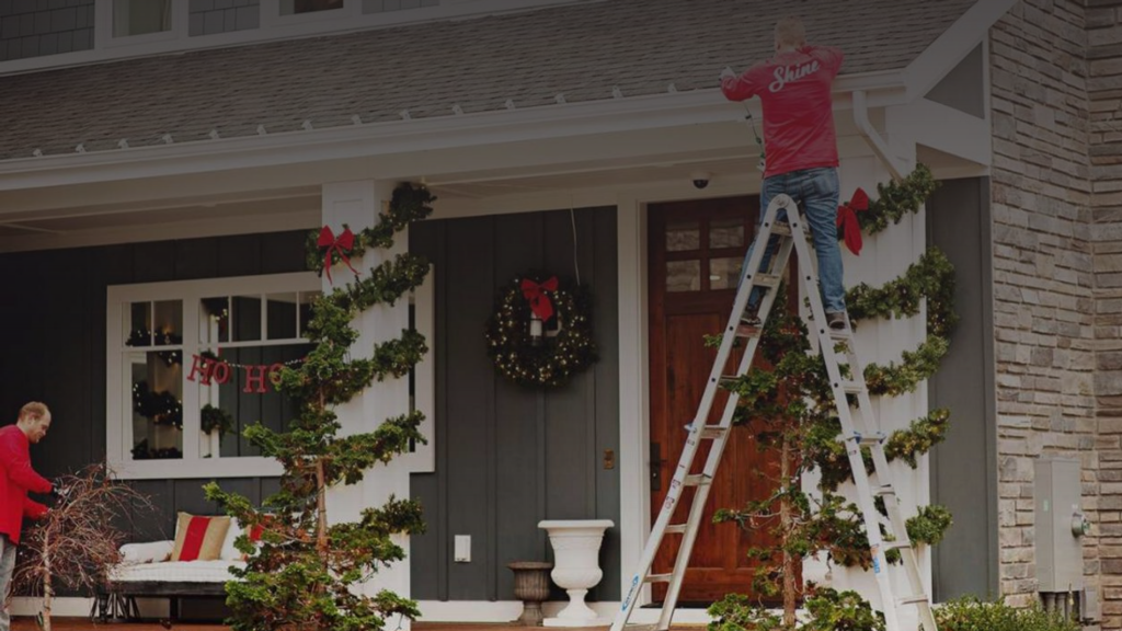 Professionals decorate a house with Christmas lights and festive garlands for the holidays. TITLE