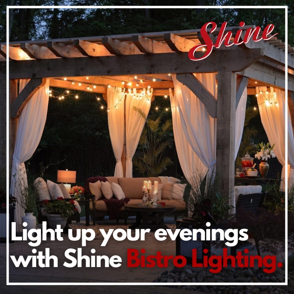 An inviting outdoor pergola features Shine Bistro Lighting, sheer drapes, and comfortable seating for evening