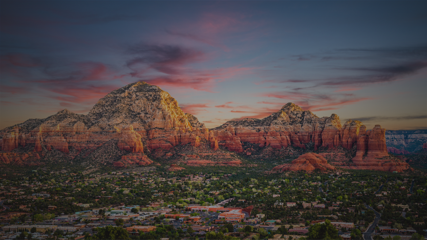 Sedona's iconic red rock mountains are bathed in golden light at sunset above the