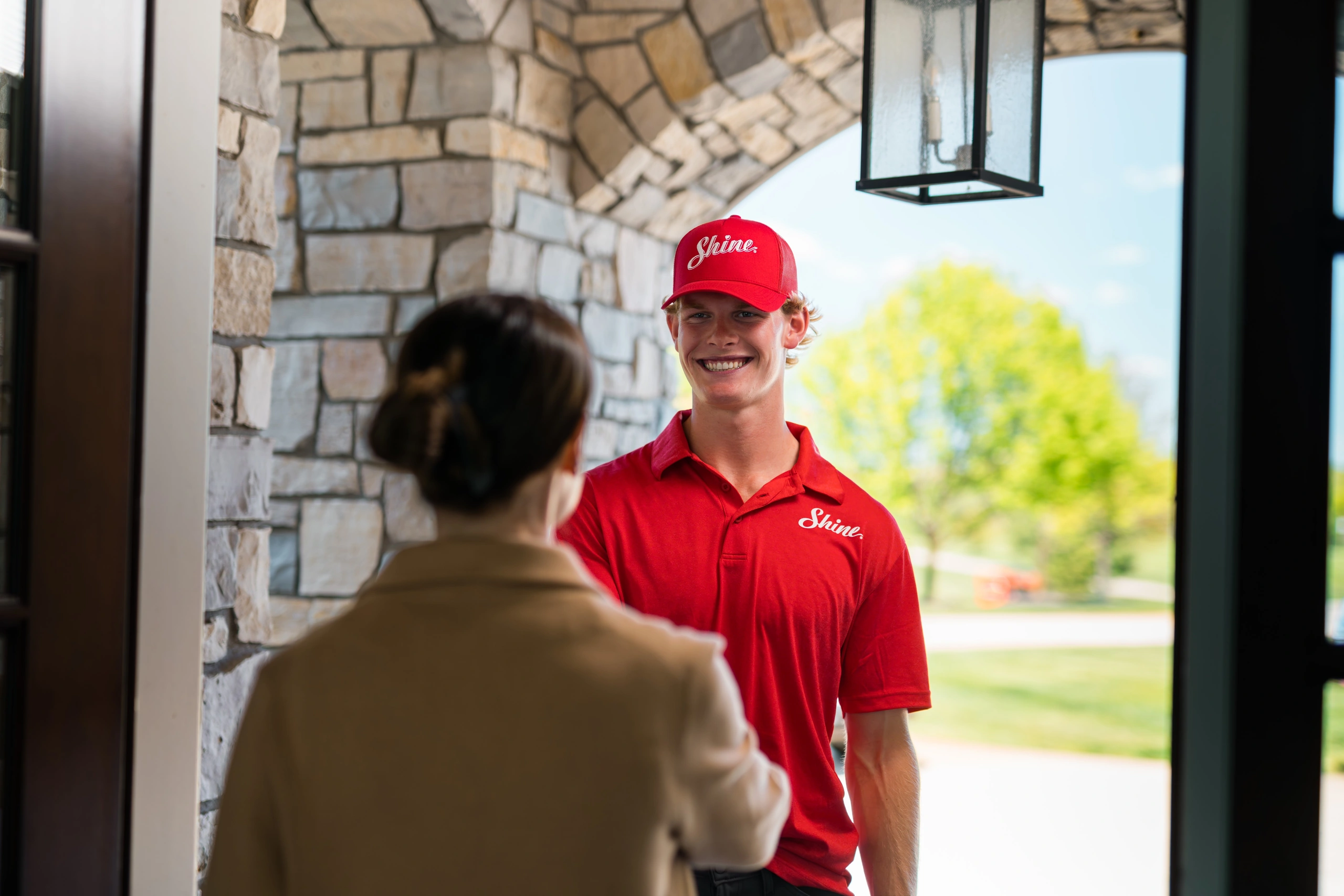 Shine technician greeting a homeowner at the front door