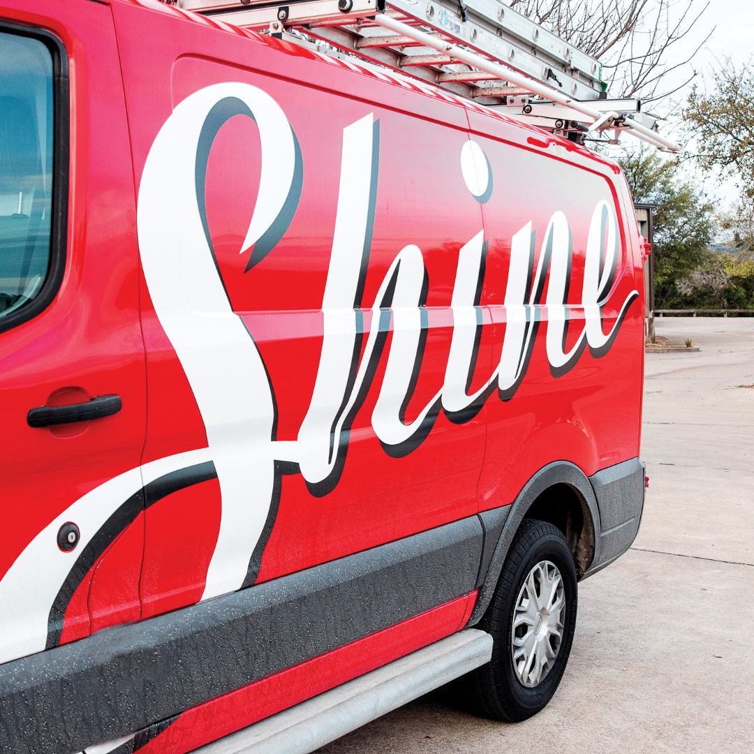 Red commercial service van with a large white 'Shine' logo and a roof ladder