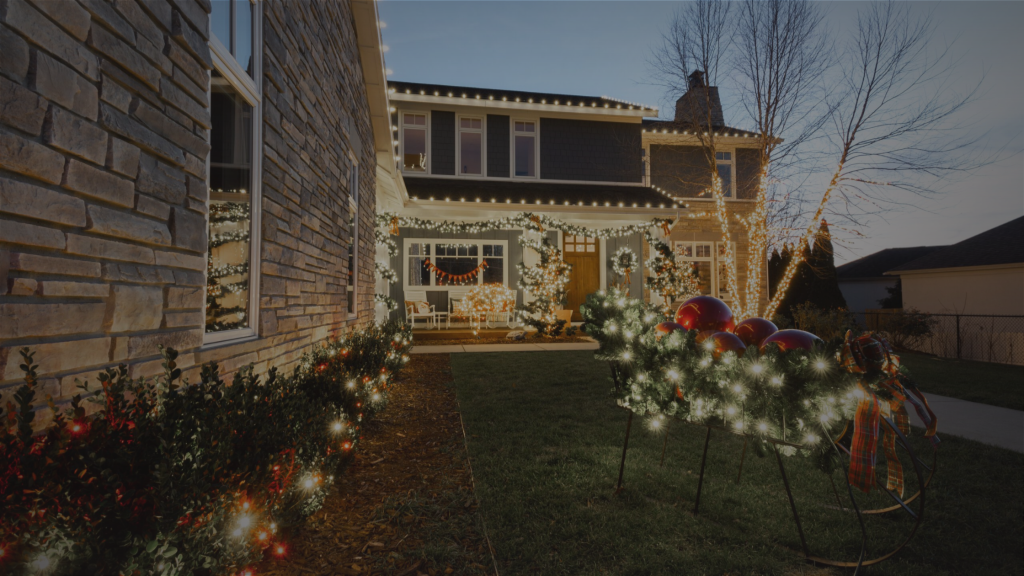 A beautifully decorated house glows with festive Christmas lights and garlands in the evening. TITLE