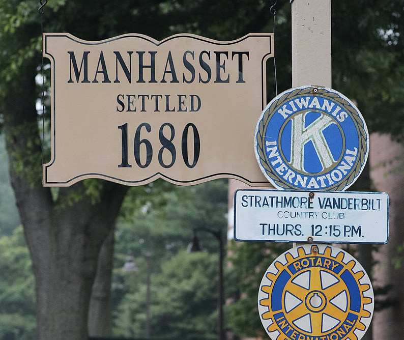 A beige sign reads "Manhasset Settled 1680," accompanied