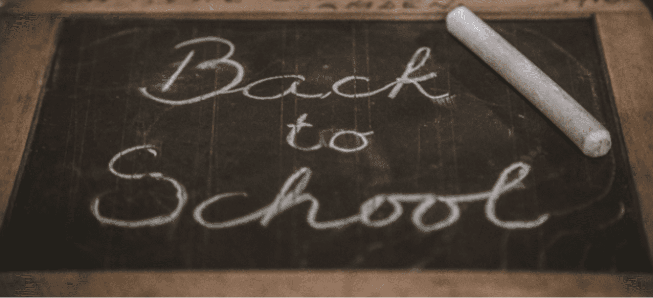 A dark chalkboard displays "Back to School" in white chalk, with a stick of chalk