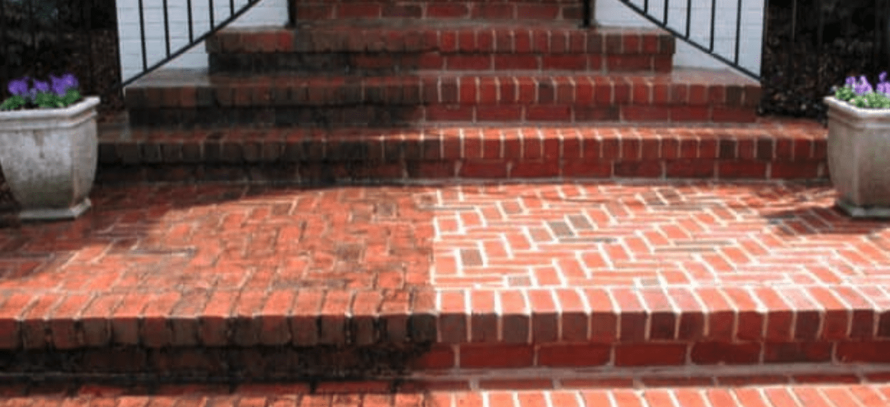 Half of a brick staircase and patio are clean, contrasting with the dirty uncleaned section.