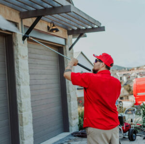 Shine employee pressure washing a garage