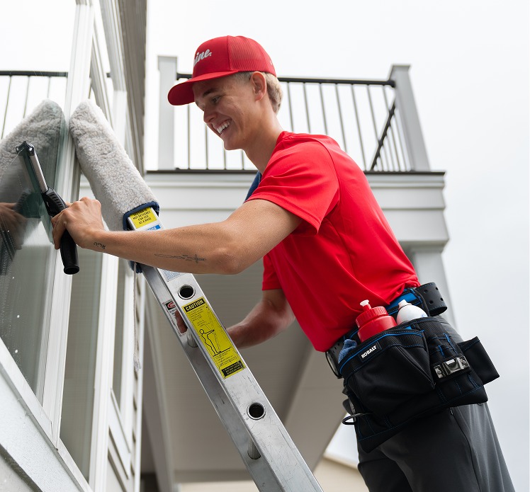 Shine technician cleaning a residential window in Scio Township