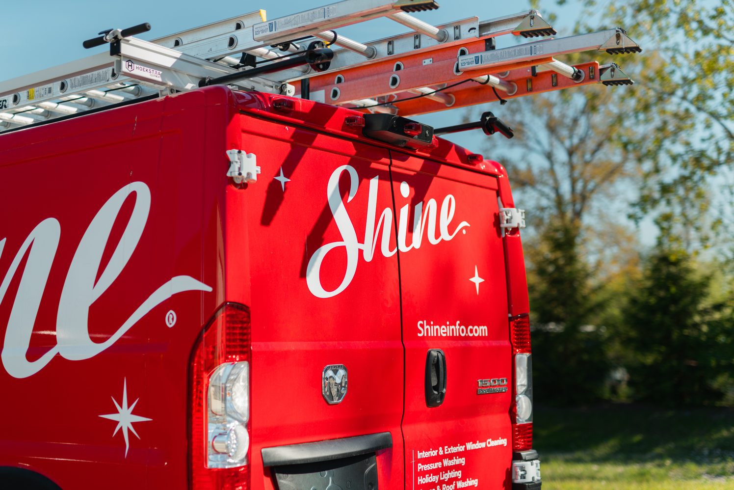 Shine service van with ladders parked outdoors