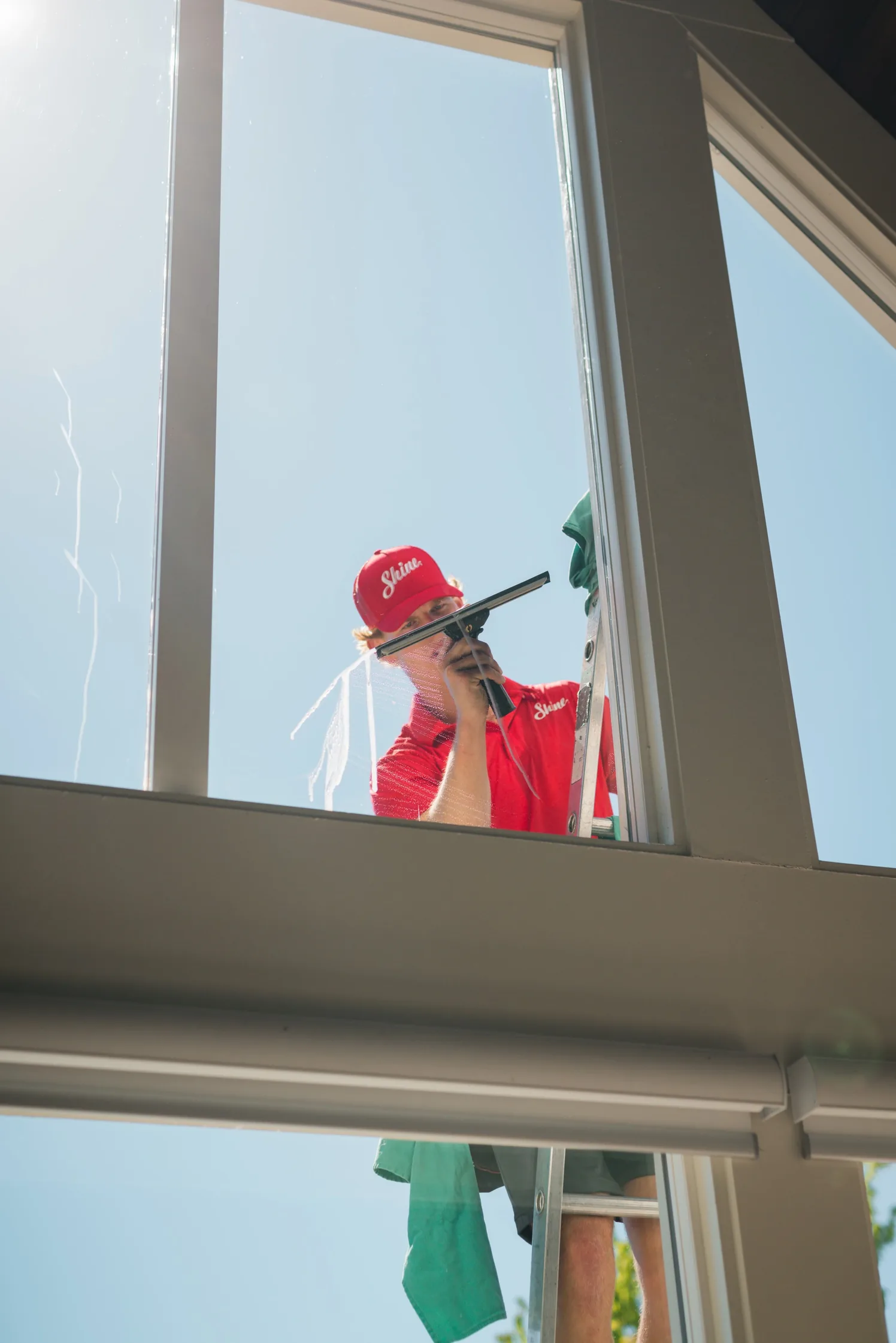 Shine technician cleaning a residential window from outside