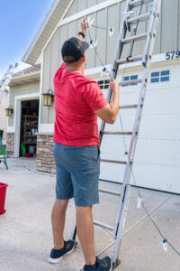 Shine team member installing holiday lights on a residential home