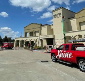 Utility truck near texas building with window cleaning team at work