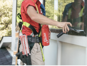 Shine team member cleaning window