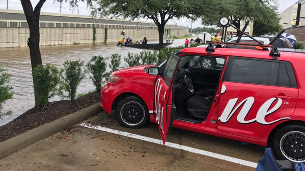 A Shine vehicle parked in front of a group of volunteers helping with flooding.