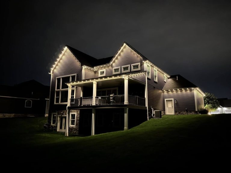 Large two-story home illuminated at night with exterior roofline lighting.