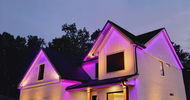 Northern modern home with pink permanent lighting on roofline on multiple peaks