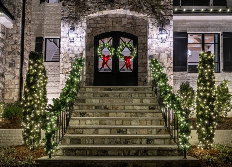 Home at dusk with red, white, and blue holiday lights along the roofline