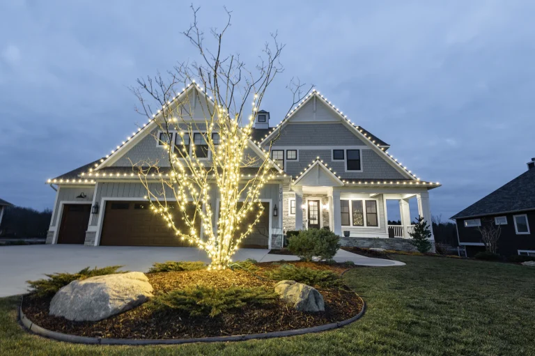 Two-story home at night with multicolor roofline lighting