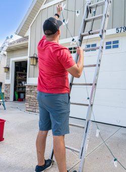 Shine team member installing holiday lights on a residential home